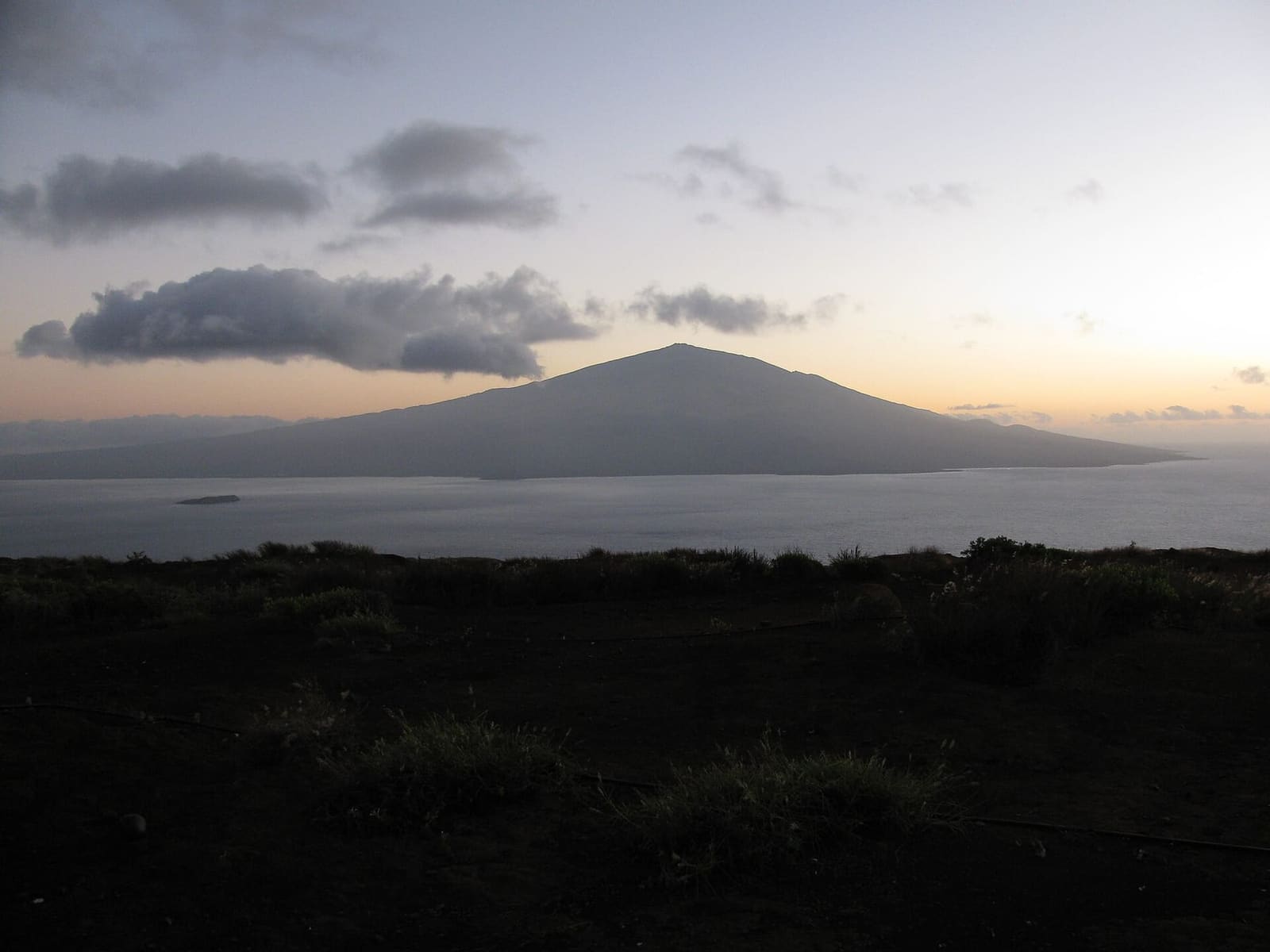 Clouds below Haleakalā at sunrise; the summit district needs a reservation before 7 a.m.
