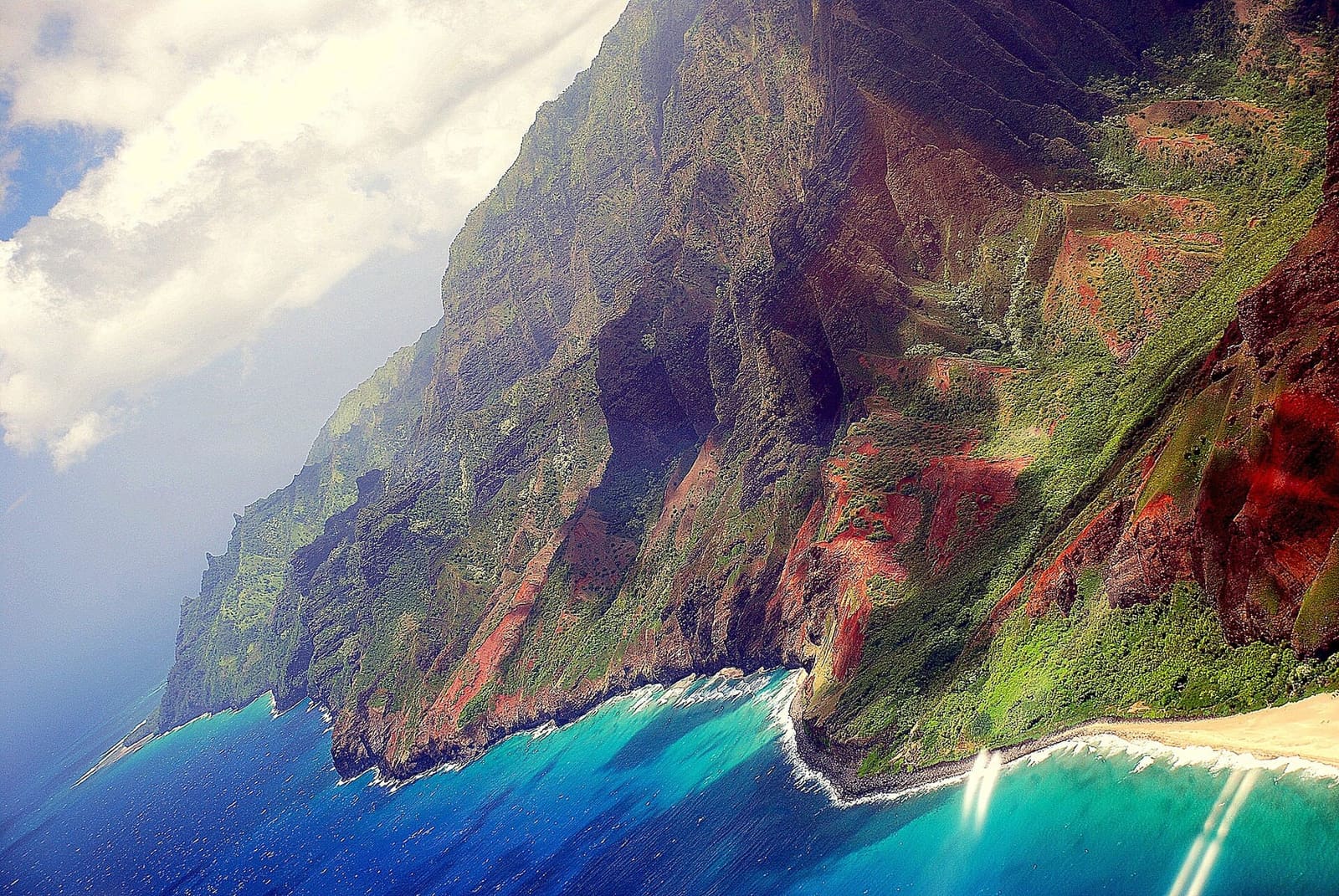 The fluted green cliffs of Kauaʻi's Nā Pali Coast dropping into the Pacific